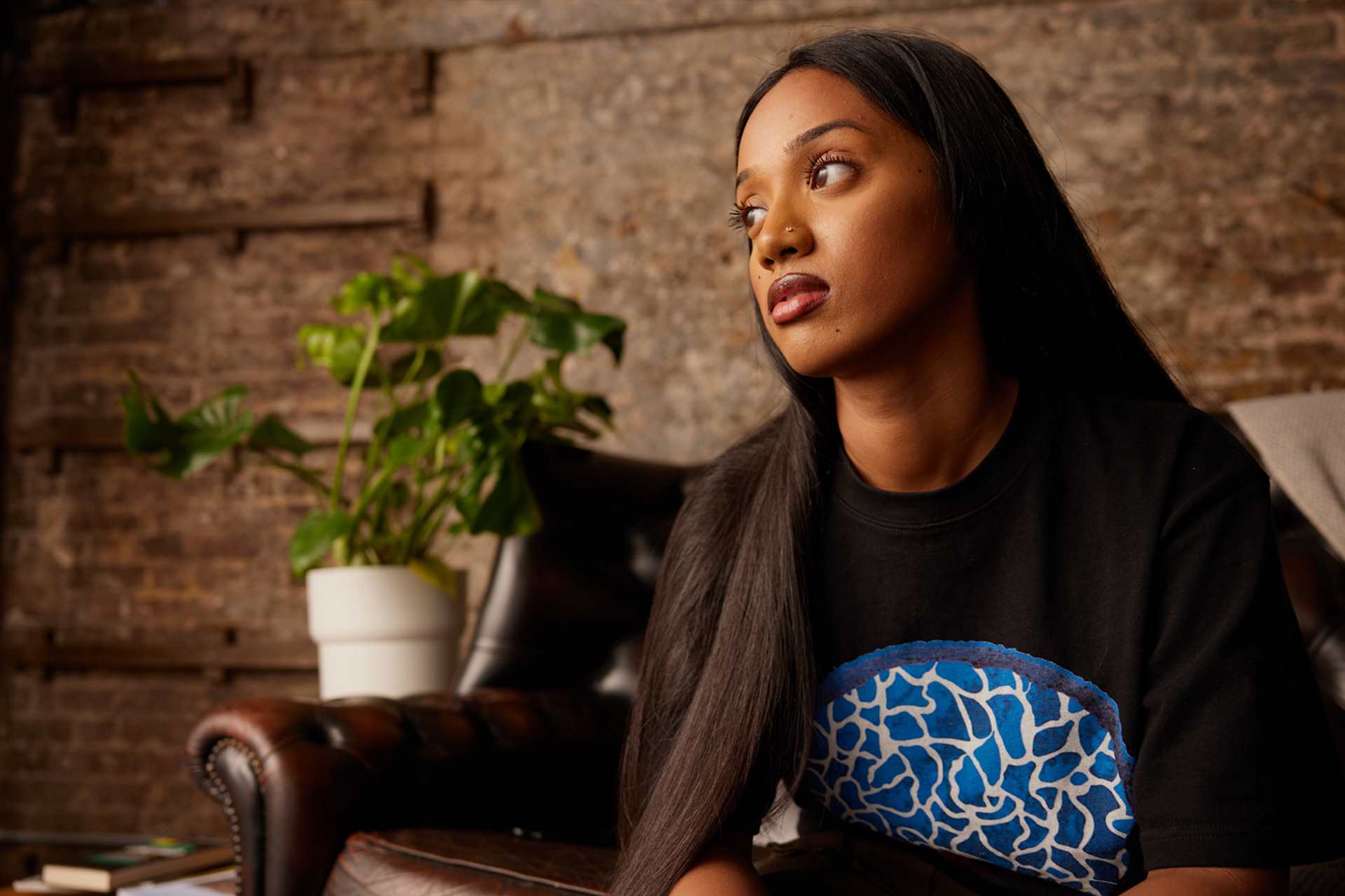 A person thinking, sat on the sofa.