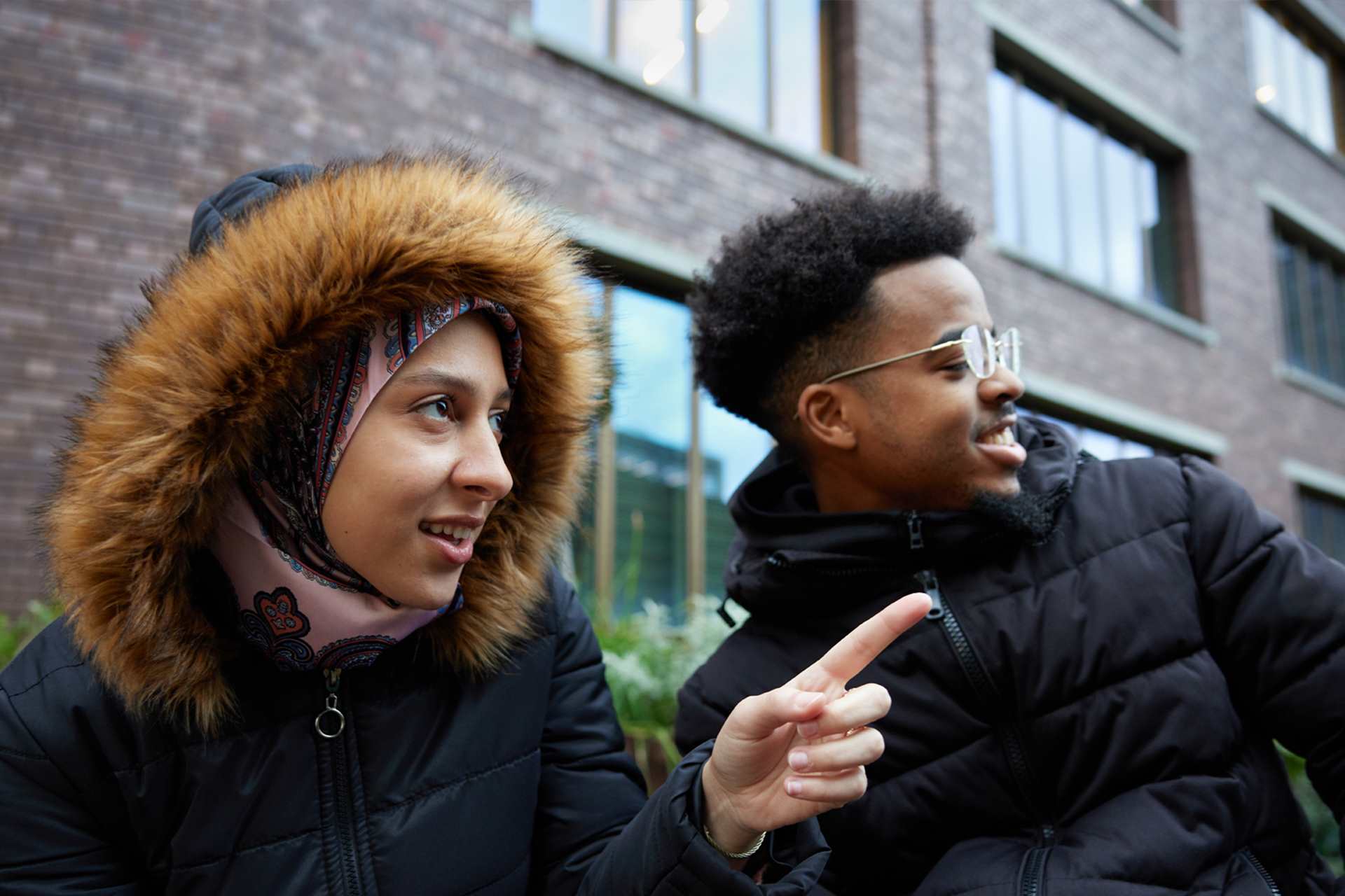 A person looking at what someone is pointing at.