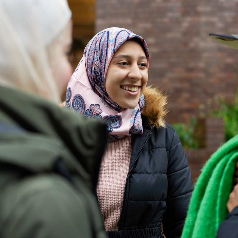 Three people chatting outside.
