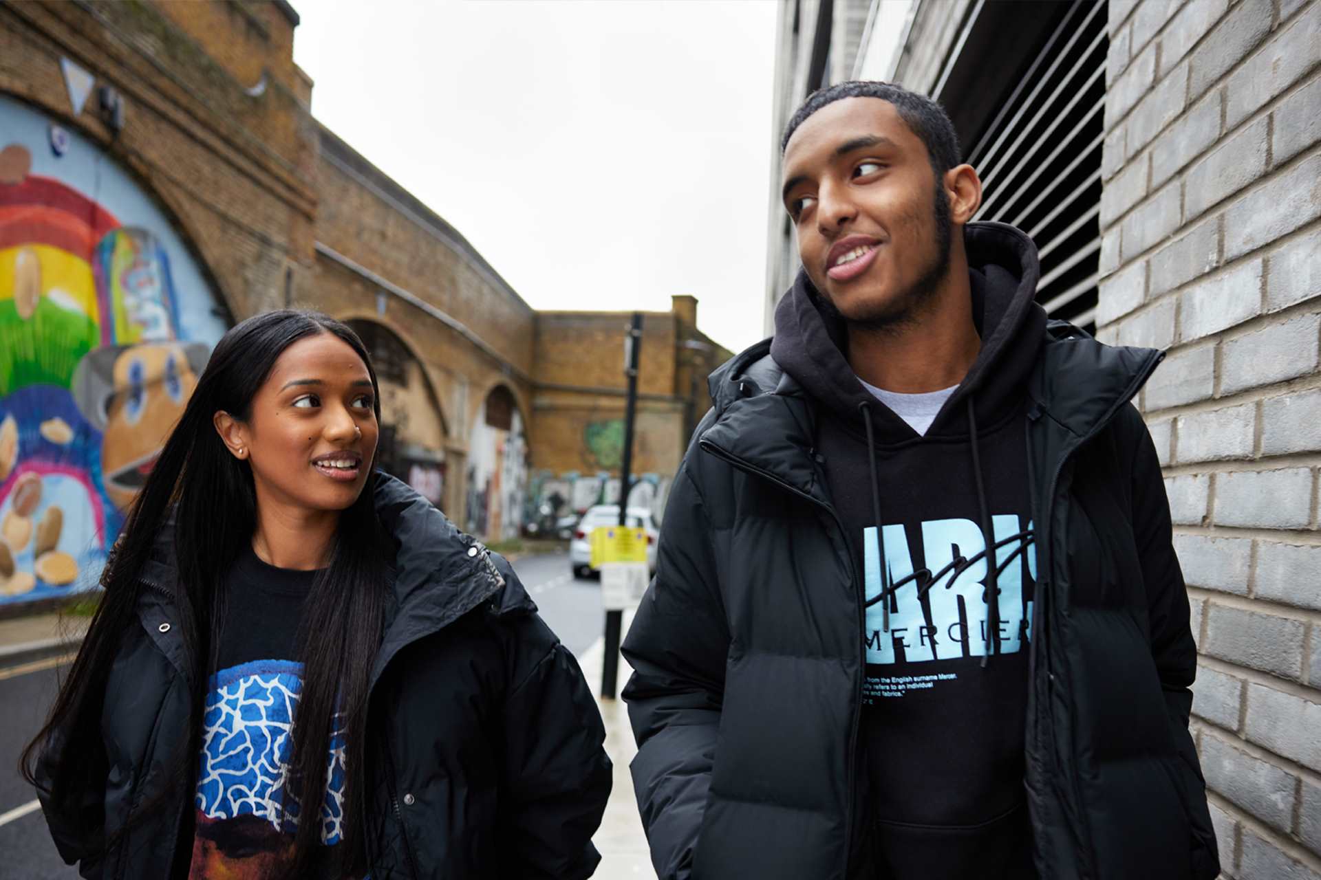 Two people walking and talking on the street.