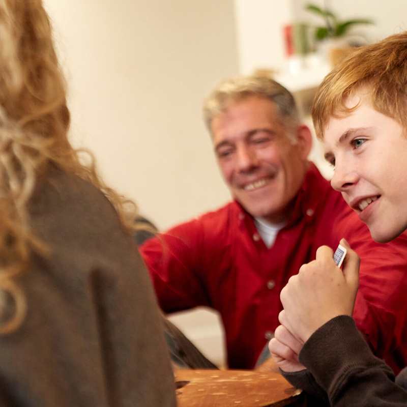 A boy and his parents smiling during a family meeting