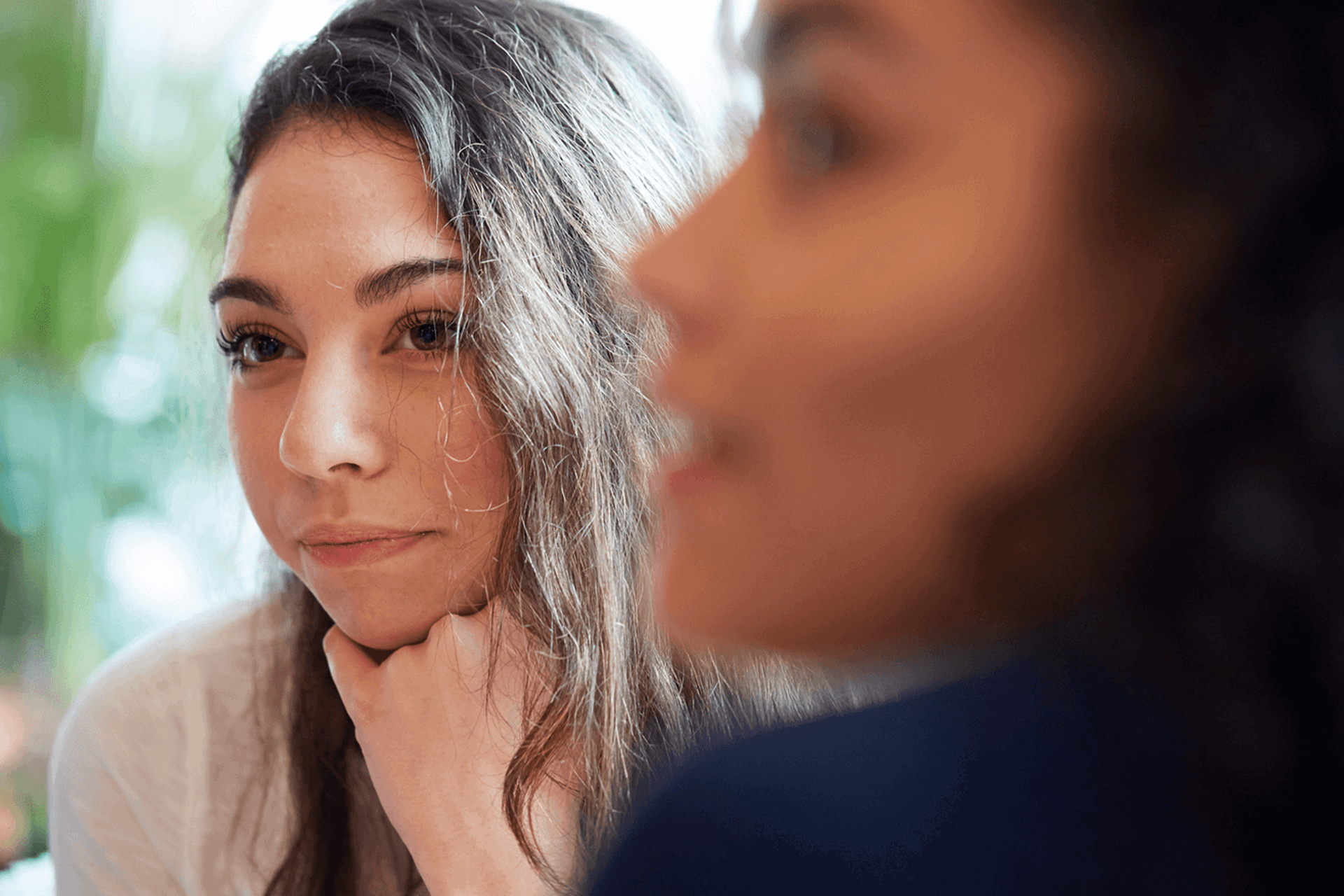 Two young people sitting together and listening to a conversation.