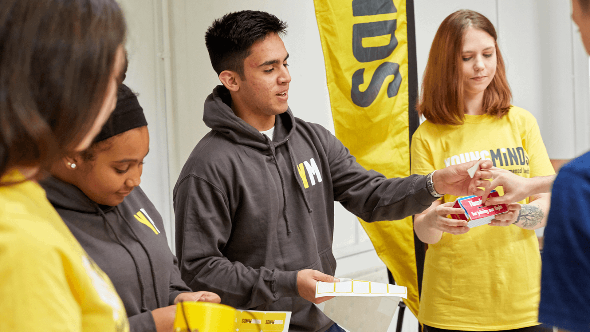mixed group of YoungMinds volunteer giving out fundraising materials