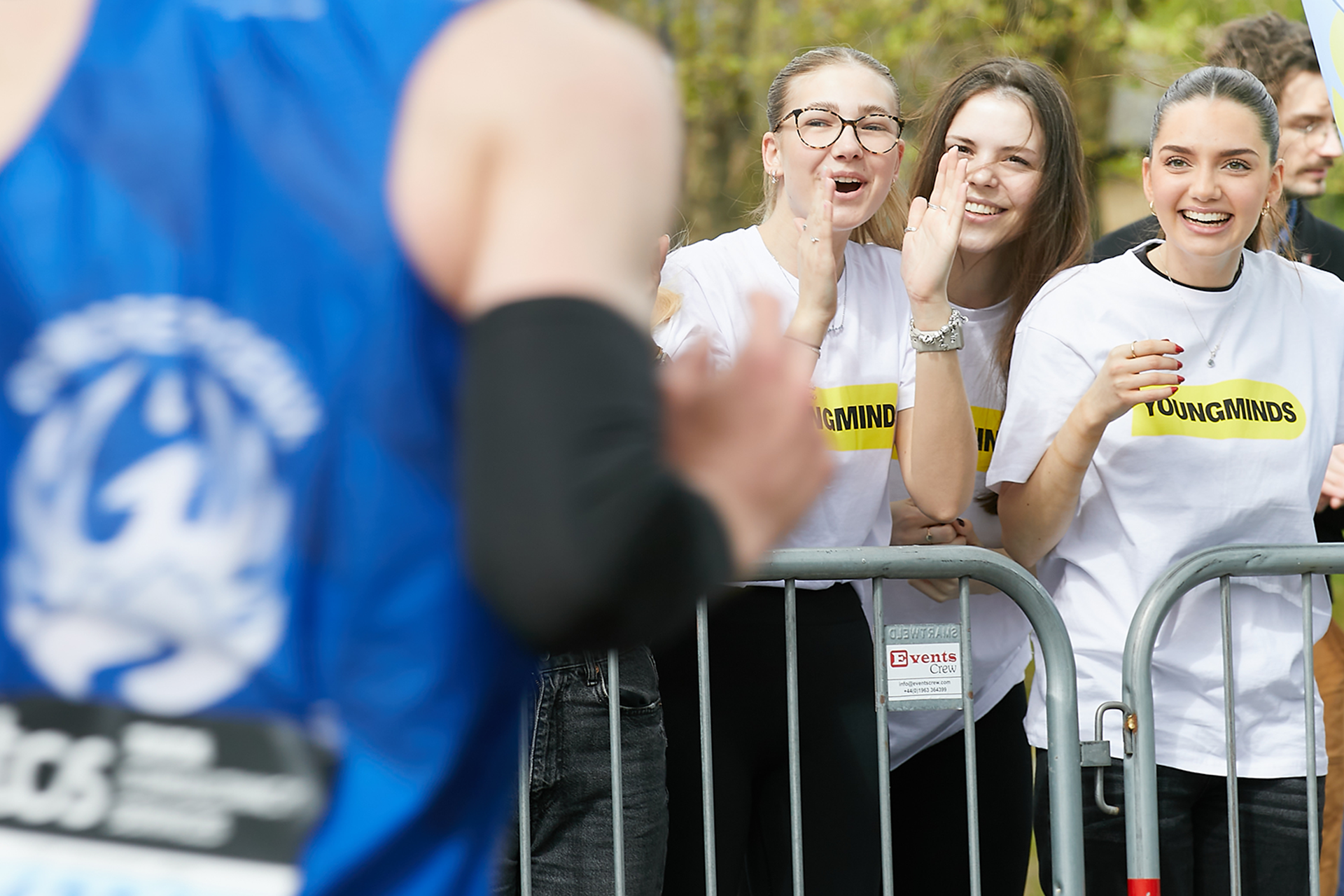 A YoungMinds marathon runner being supported by YoungMinds staff on the side line.